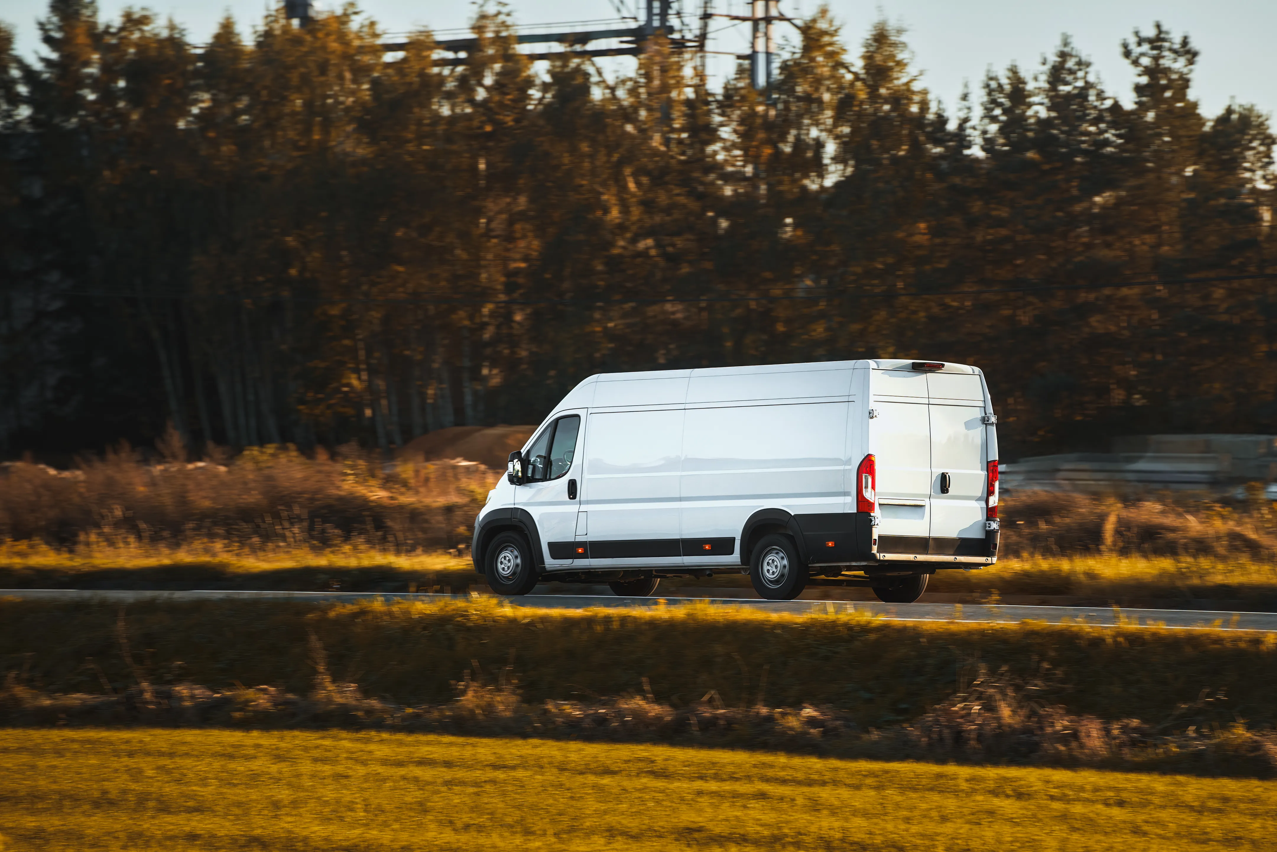 White extra long wheel base delivery van on the road